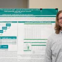 Biostatistics graduate student, Calvin Andrews, standing in front of his poster.